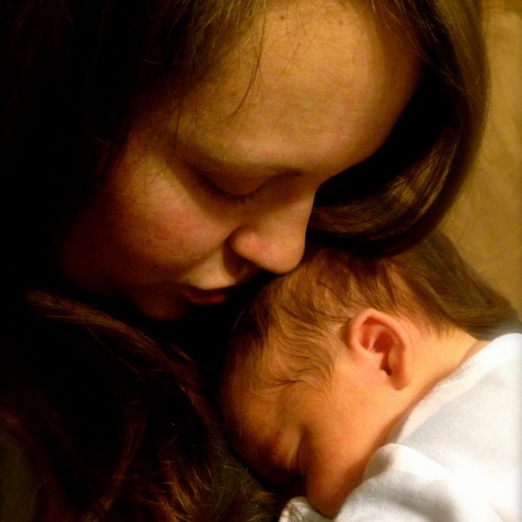 Child laying on woman's chest, mother looking down
