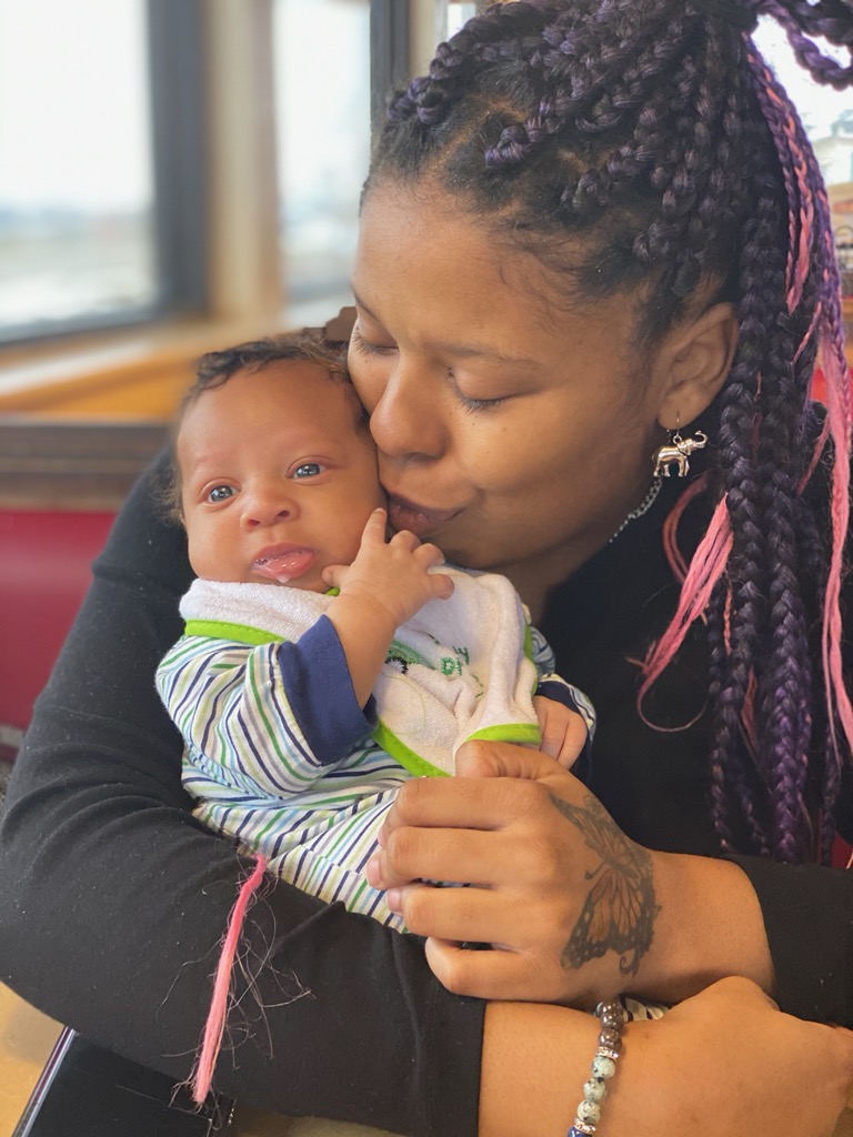 Mother holding and kissing her baby, who was born with the help of a birth doula in Columbia, MO. Doula Danica Wolf with Harmony Birth Services of Missouri helped this momma birth in a hospital the way she wanted to.